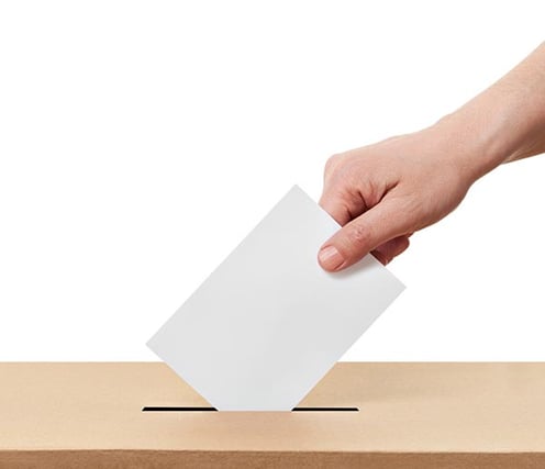 Person putting HOA ballot into voting box