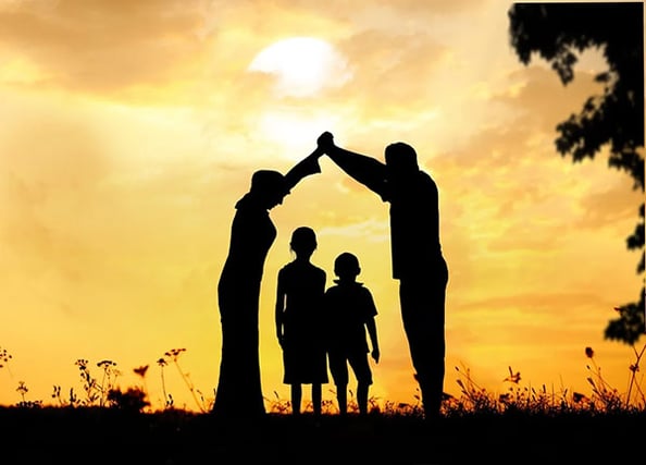 family holding hands at sun set
