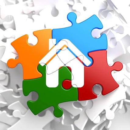multi-colored puzzle pieces with house in the middle
