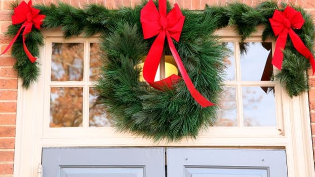 christmas wreath hung above front door of home in HOA community