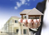 person holding small model of a house related post image