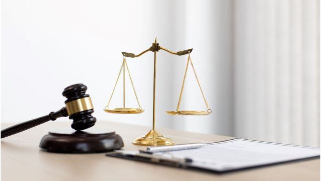 legal scale and gavel on desk with clipboard